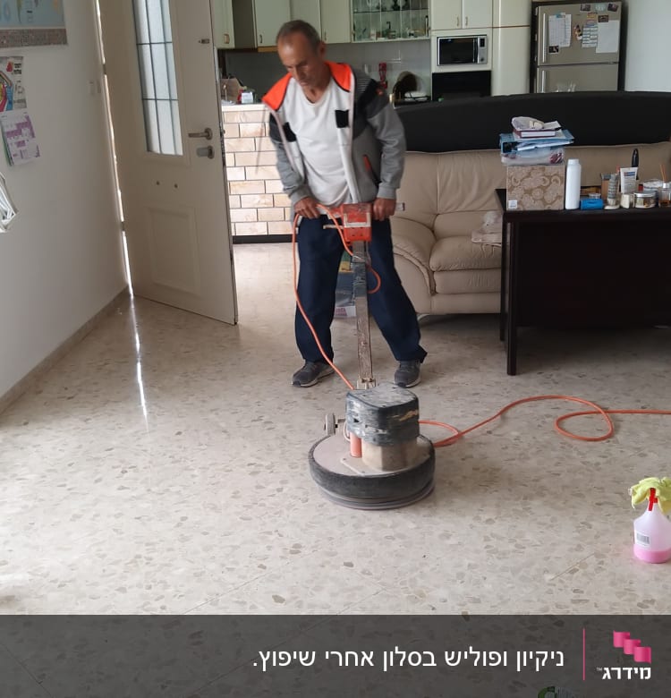 אדם מנקה רצפה עם מכונת פוליש חשמלית